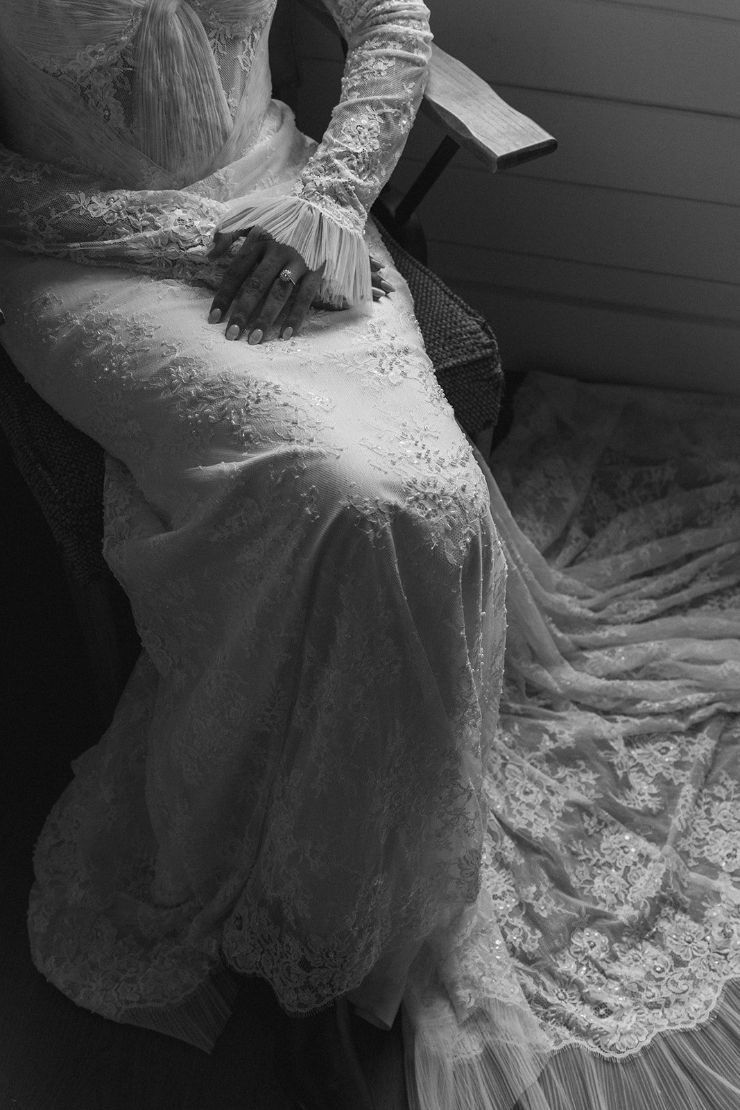 Bride seated in her lace wedding dress before the ceremony, showing delicate sleeve details and her engagement ring at Bright Morning Farm.