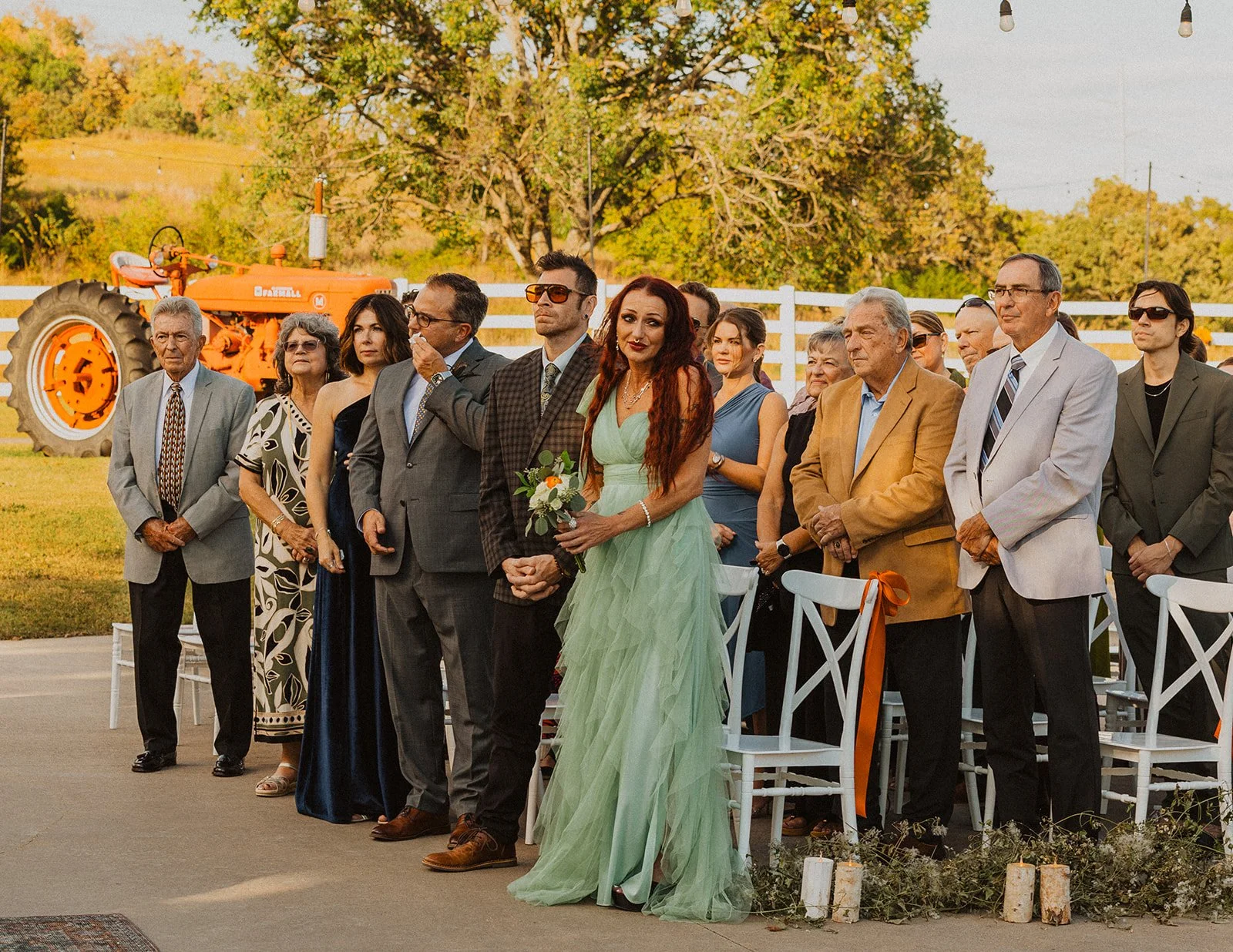 Bride and groom posing with their wedding party beneath the signature stone ceremony arch at Bright Morning Farm in Oklahoma.