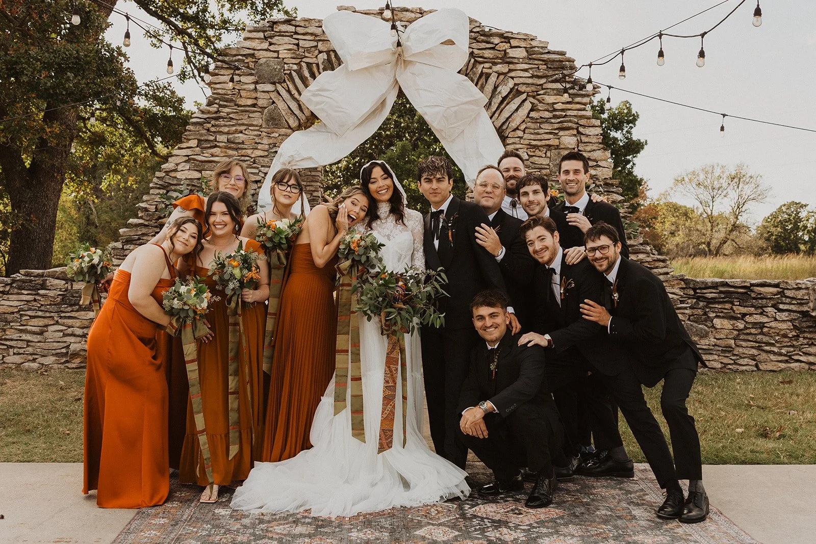 Wedding guests watching the outdoor ceremony at Bright Morning Farm, with family gathered in front of the ceremony space and a vintage orange tractor in the background.