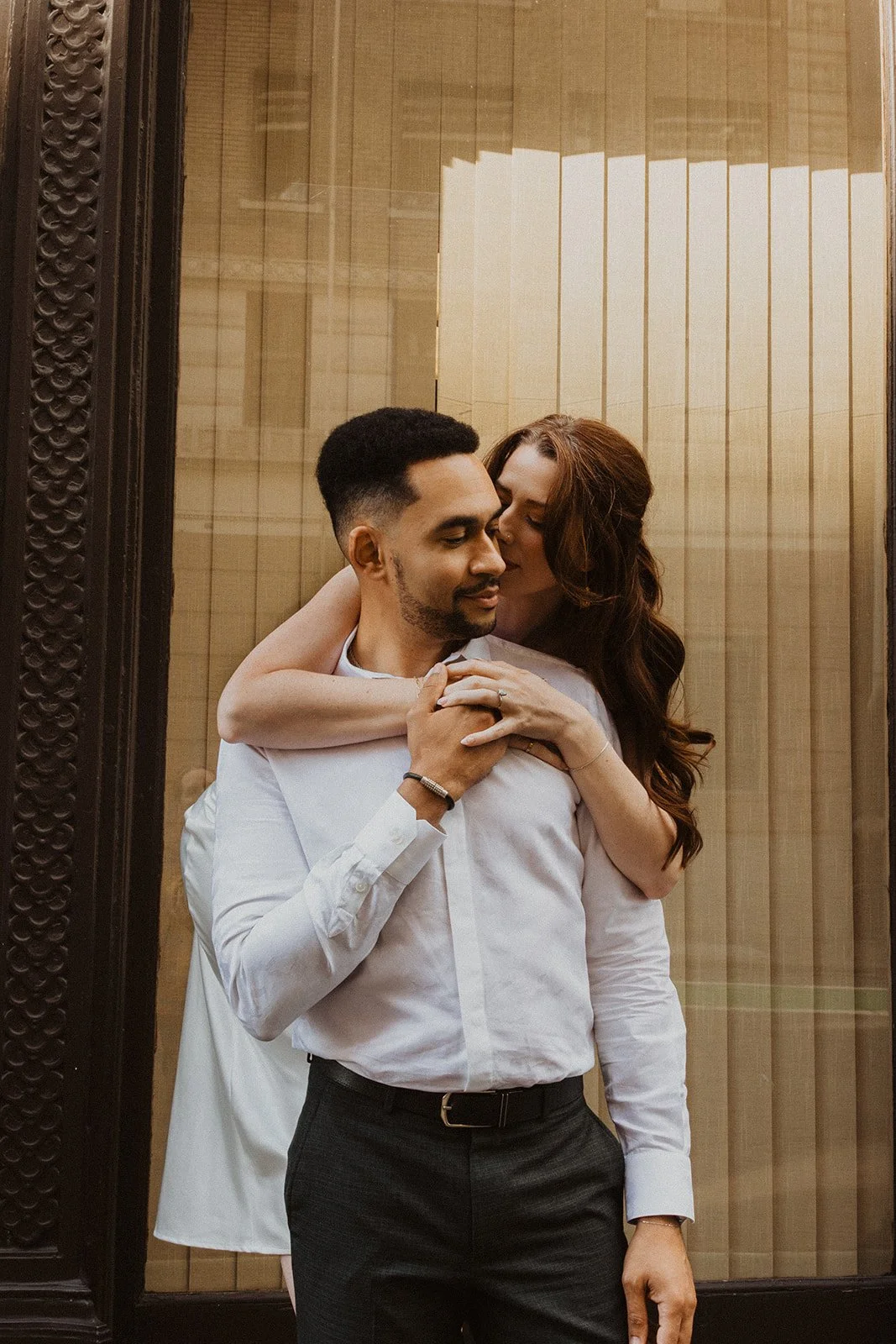Couple sneaking a kiss on the cheek during their Portland city engagement session