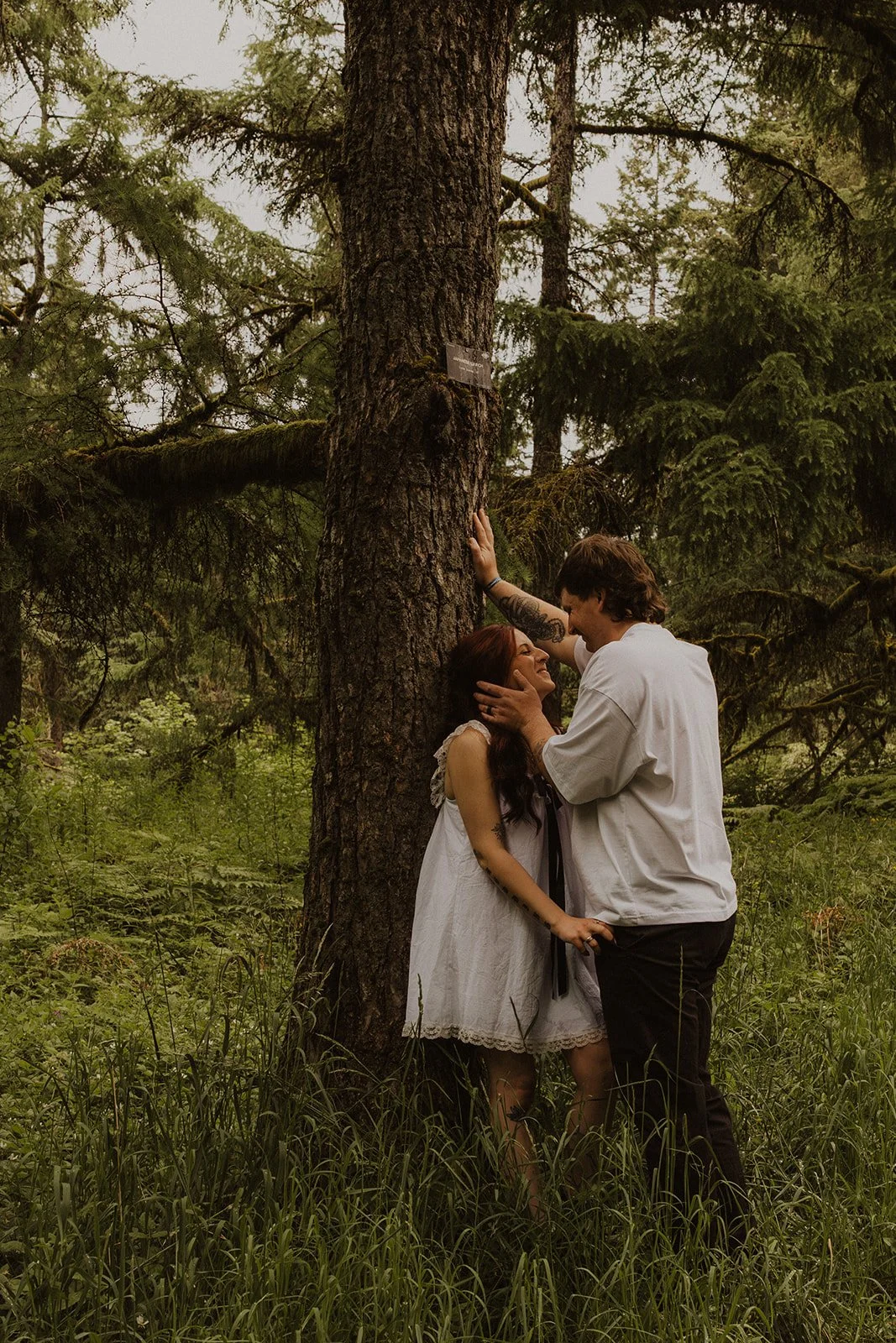 Couple walking a mossy trail during an Oregon forest engagement session