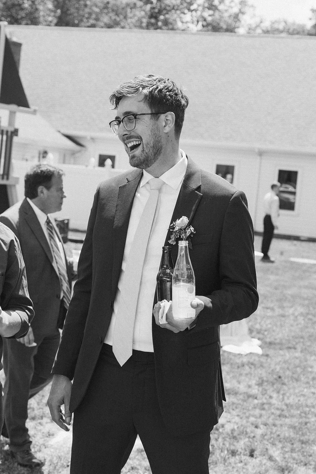 Groom laughing mid-conversation instead of posing for the camera