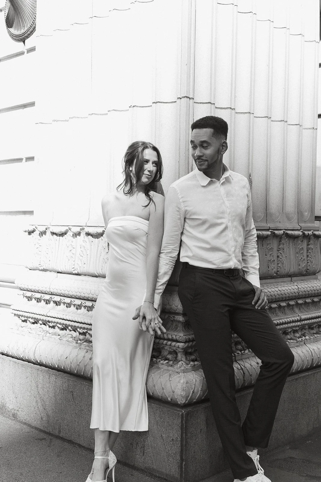 Couple leaning against an old brick wall in downtown Portland