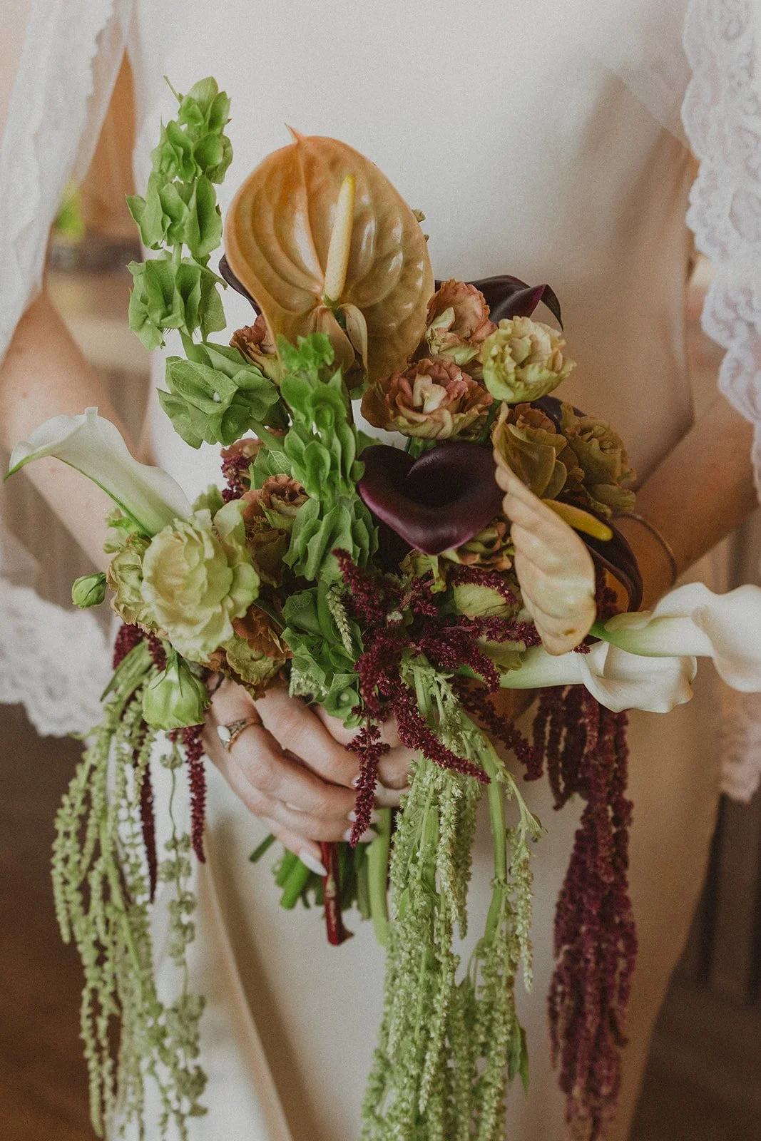 Rings and a trailing bouquet held at her side at an Oregon vineyard wedding