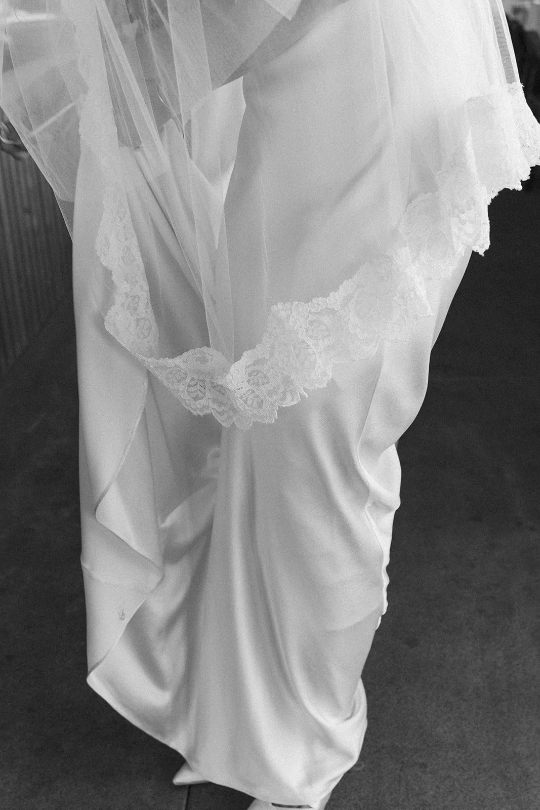 Lace veil edge falling across satin, photographed in black and white
