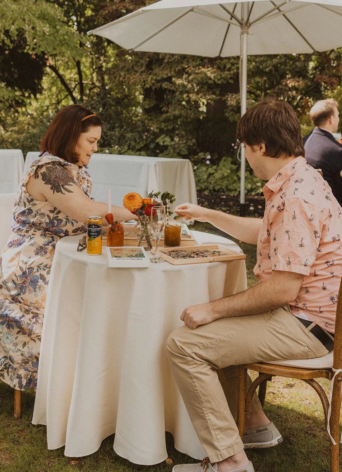 Two guests work on the puzzle together during an afternoon garden reception