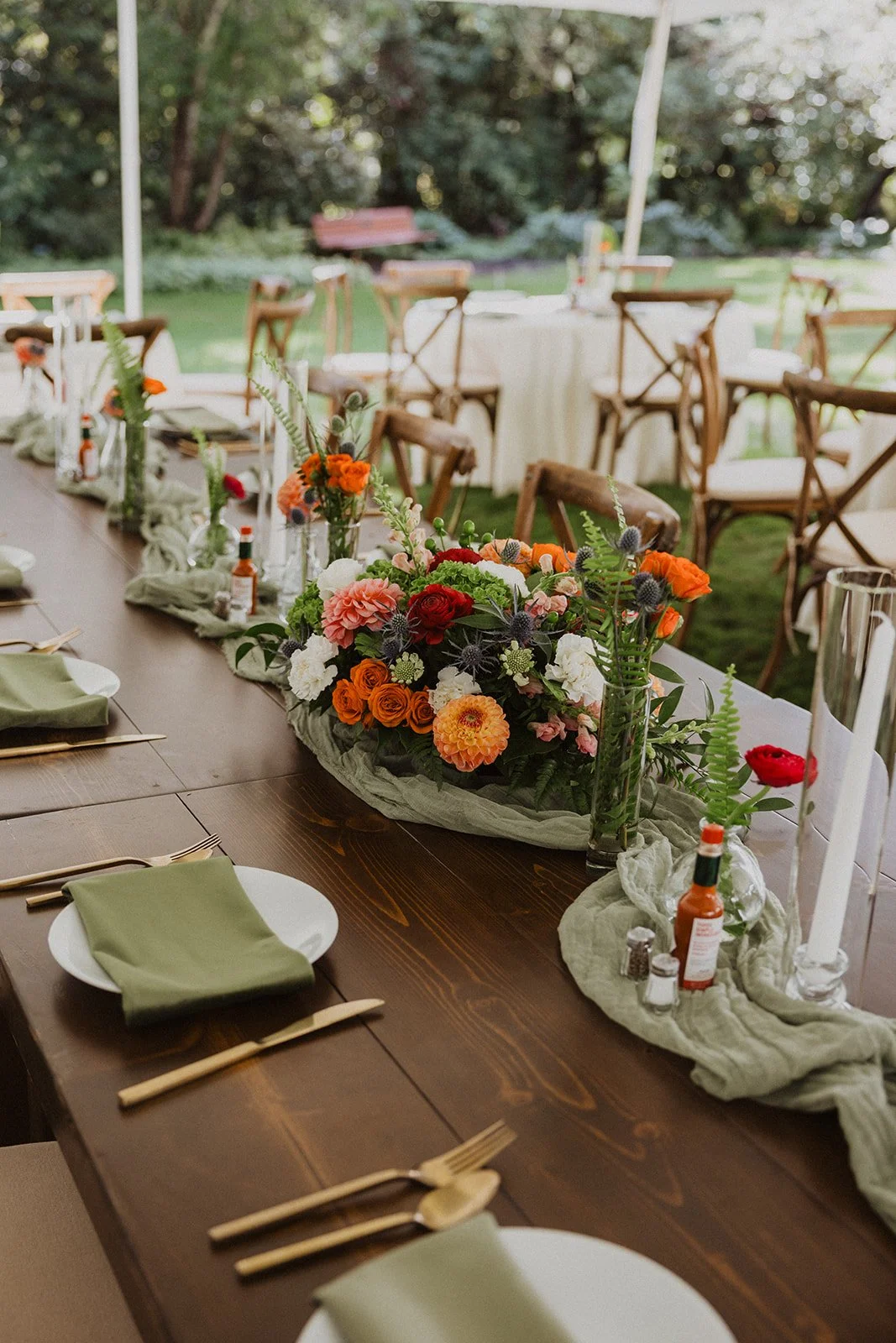 Farm table and cross back chairs under a white tent at Crystal Springs