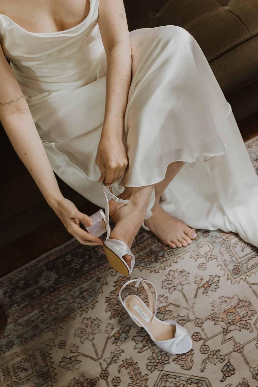 Fastening a satin ankle strap before a Rocky Hill wedding ceremony