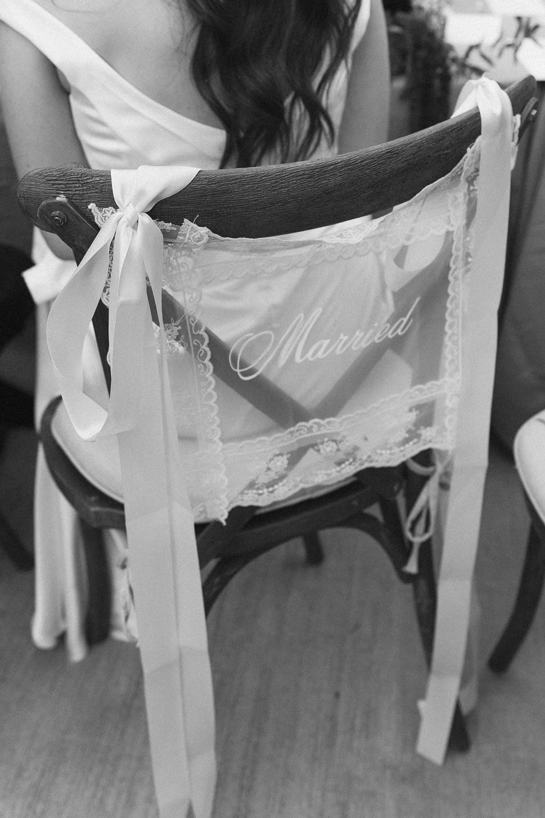 Lace chair cover tied on with satin ribbon at the reception table
