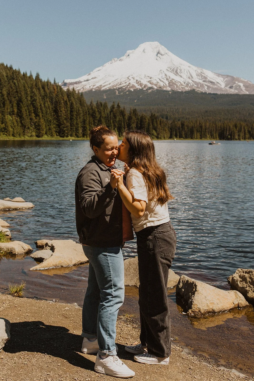 Kissing her cheek with their hands still clasped at this Mount Hood lake