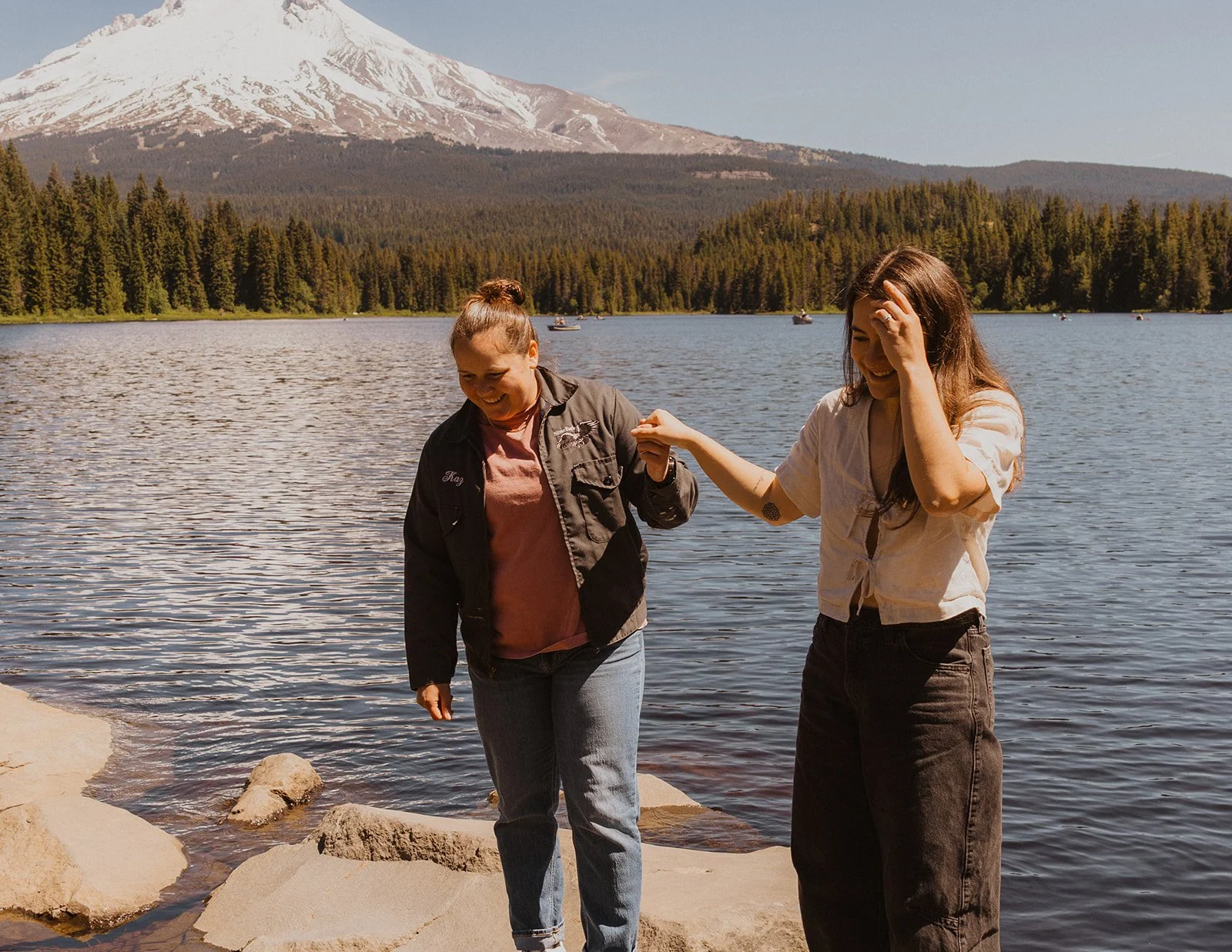 Pushing her hair back and laughing on the rocks with the new ring on