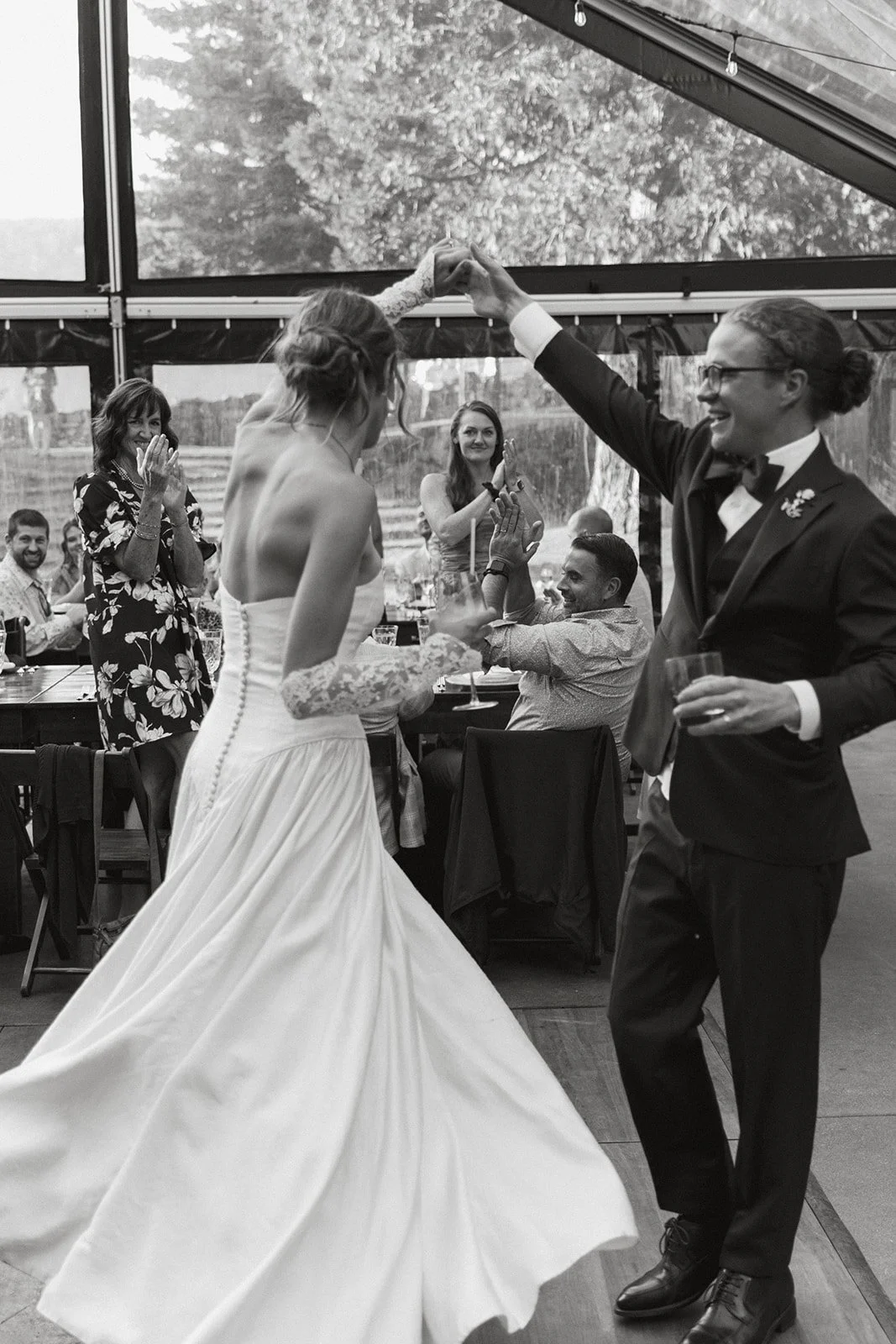 Twirling on the dance floor inside a tent while guests applaud