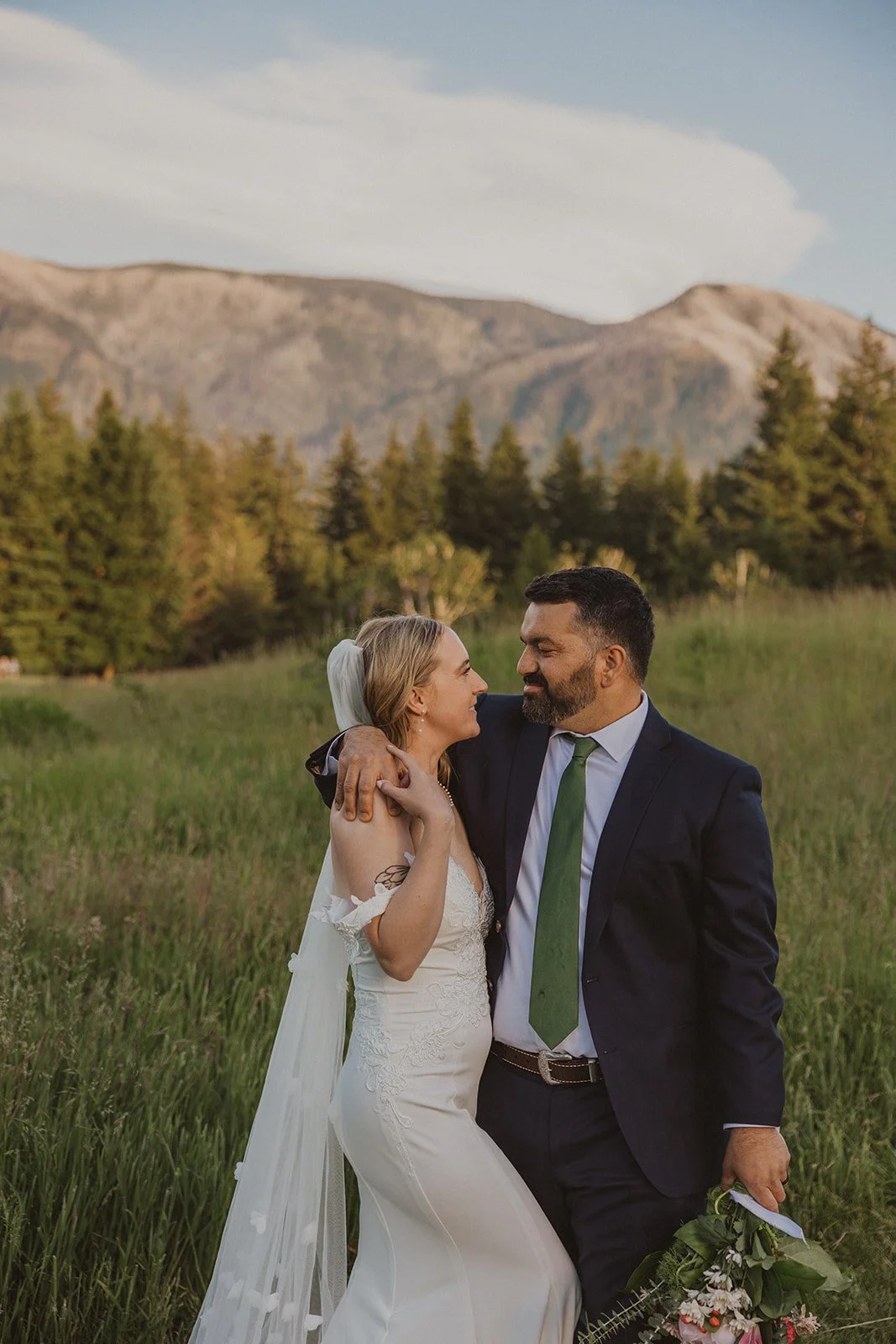 Looking at each other in tall meadow grass with a ridge behind