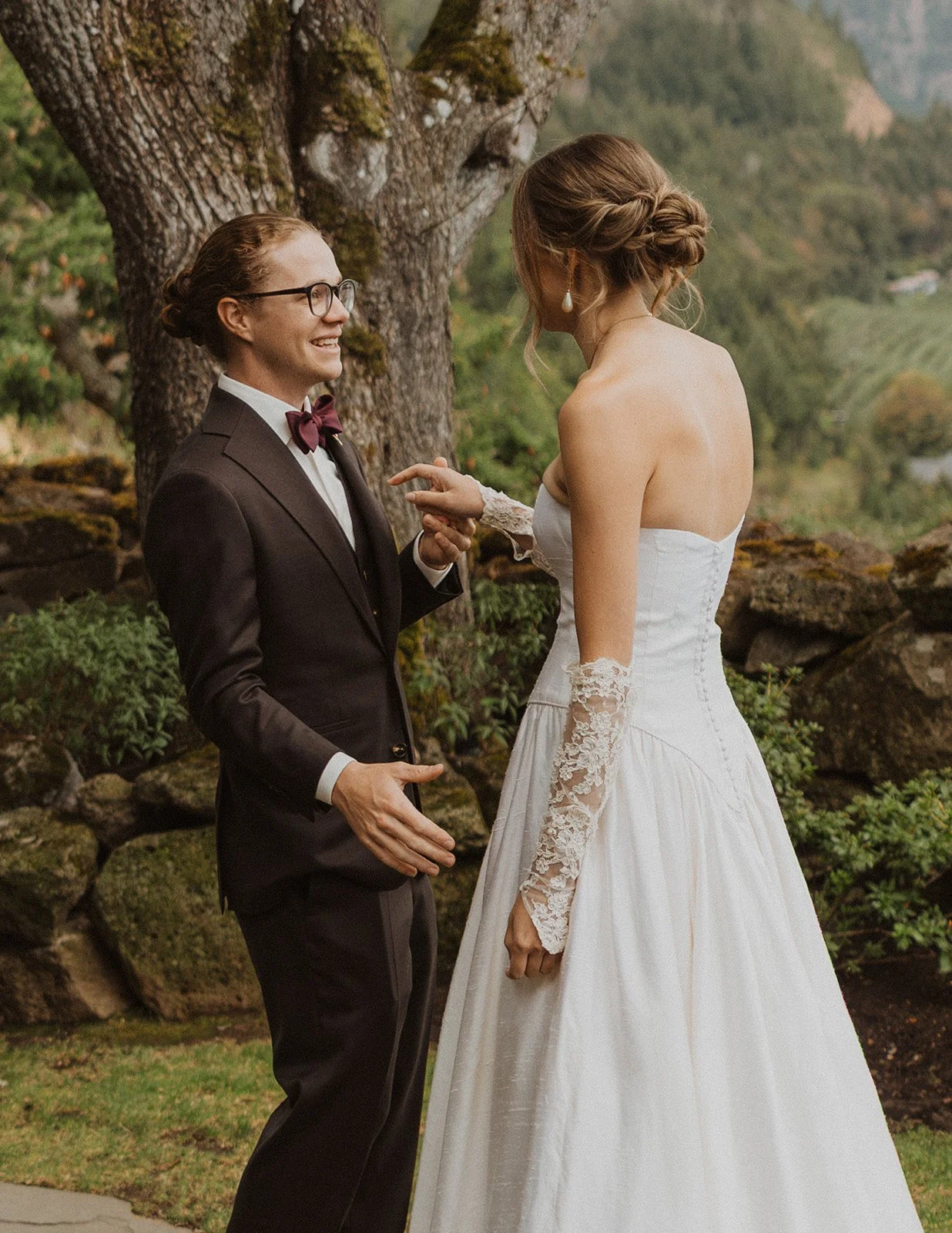 Talking face to face by a mossy wall with canyon slopes behind