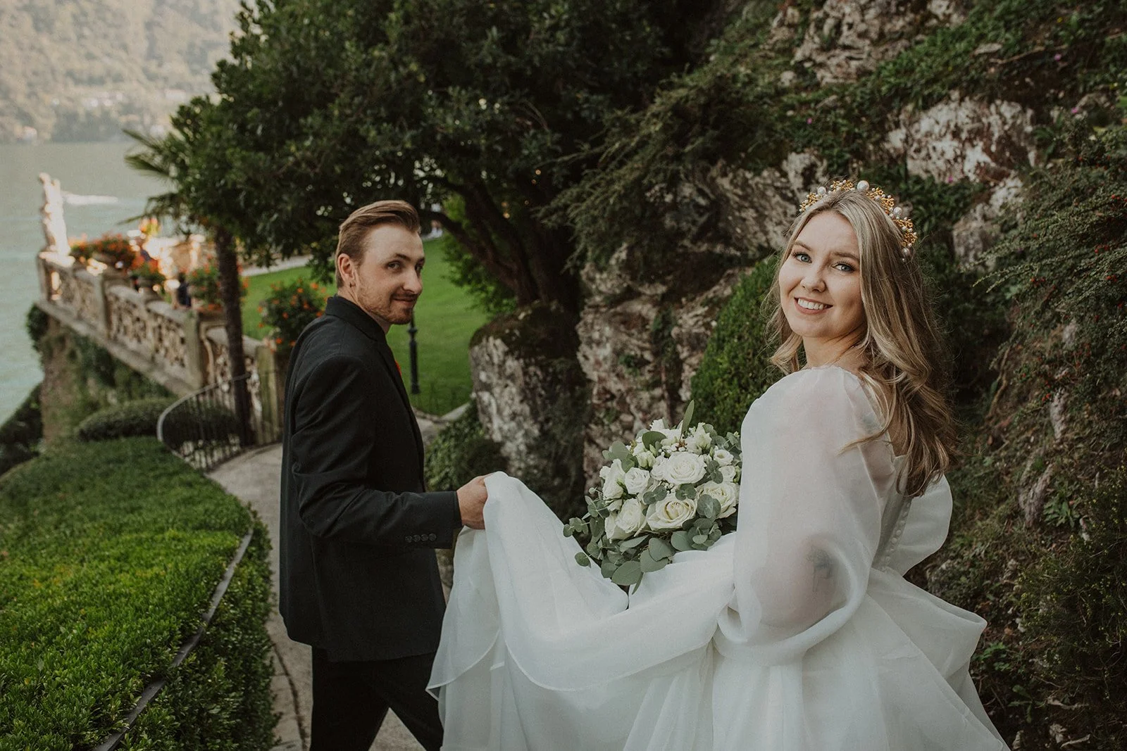Bride and groom walking along the garden pathway at Villa del Balbianello after their Lake Como elopement ceremony.
