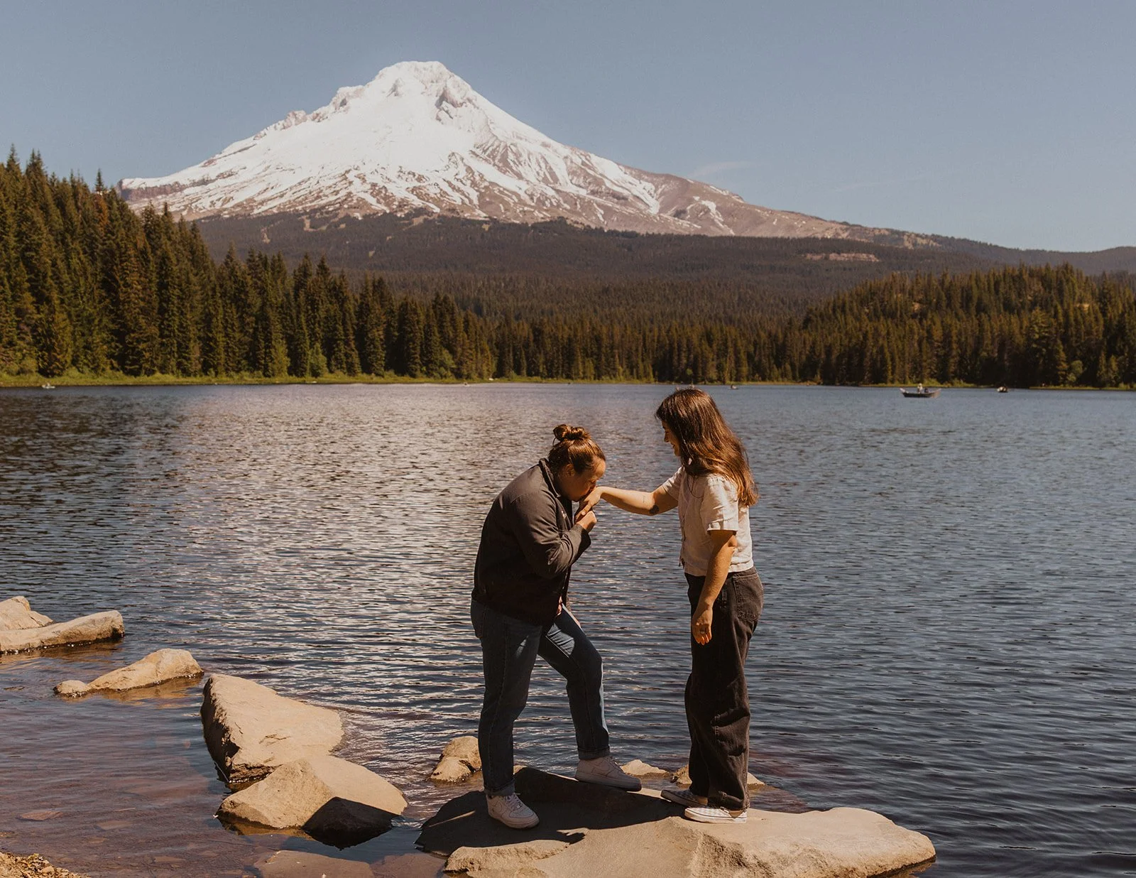 Kissing her hand out on the rock in Mount Hood engagement photos