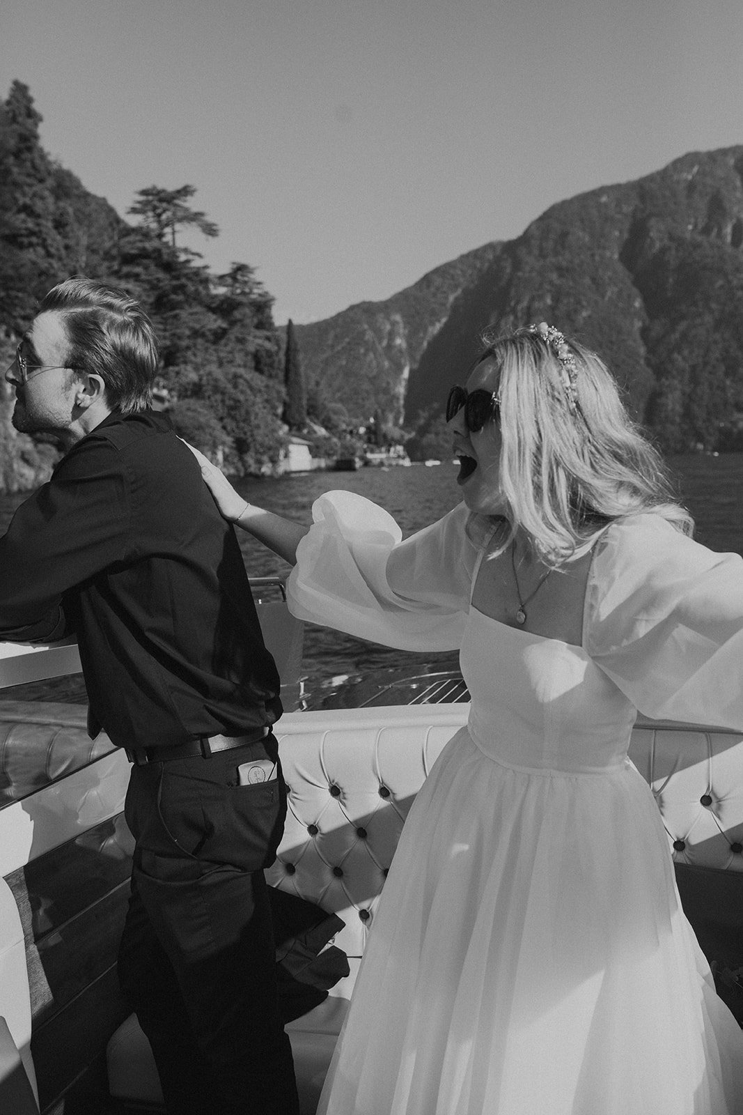 Black and white image of bride and groom celebrating on a boat in Oregon for their PNW wedding, captured by a Oregon wedding photographer