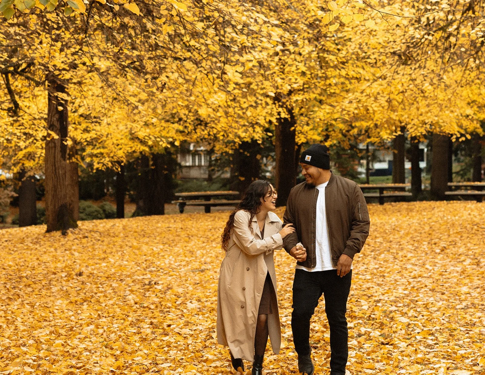 Laughing mid-walk with Portland fall color filling the frame behind them