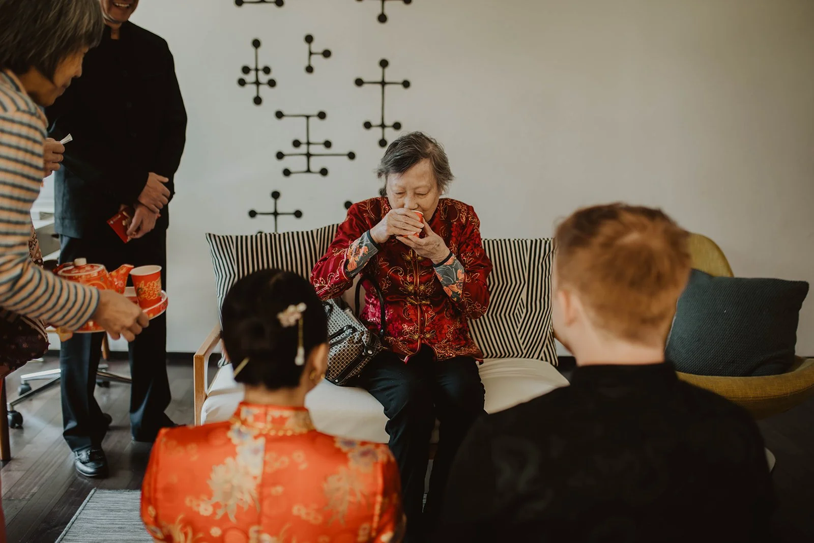 Grandmother receives tea from the couple during a traditional Chinese tea ceremony honoring family elders before the wedding.