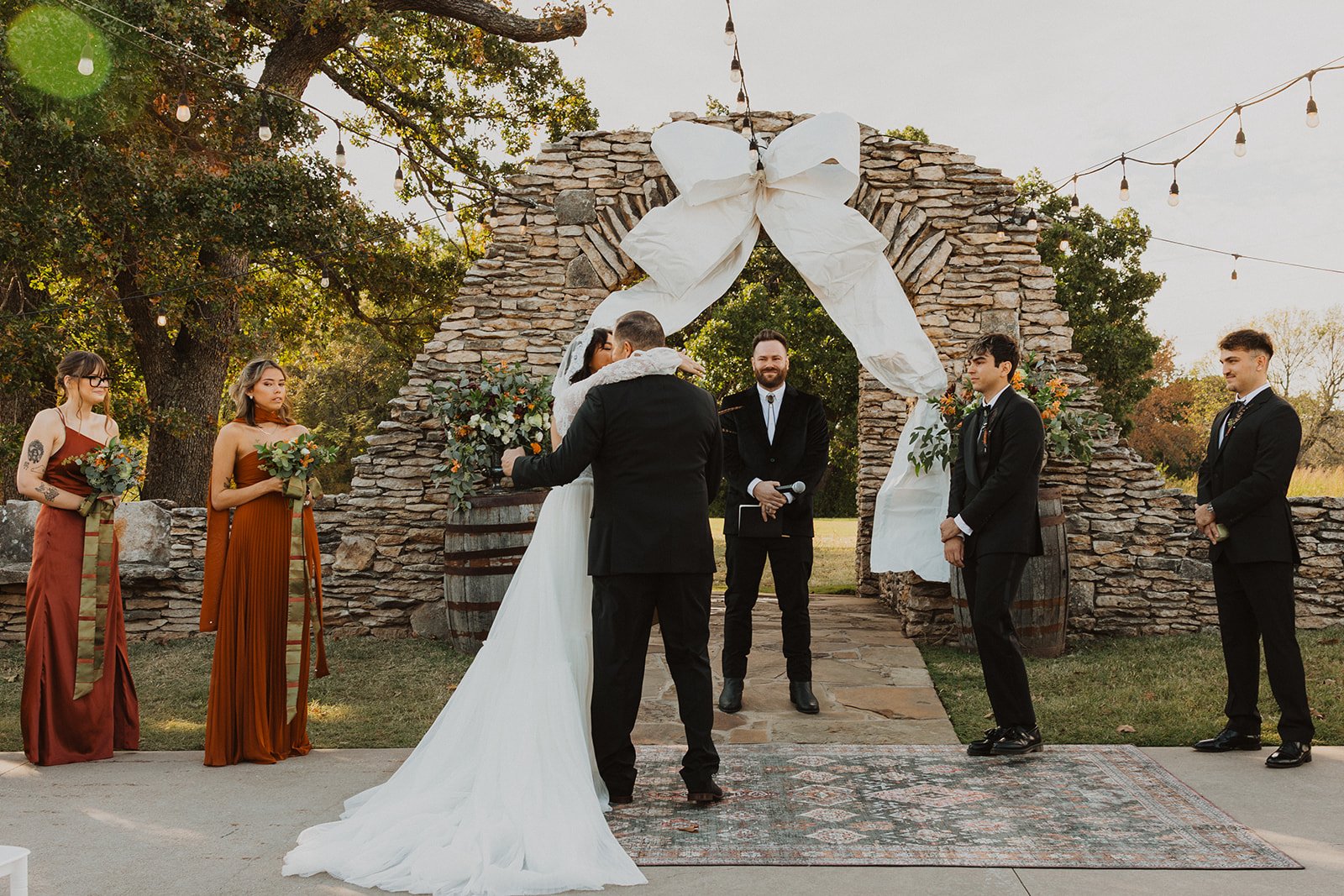 Bride hugging her father at the altar before the ceremony begins at Bright Morning Farm while the wedding party looks on.