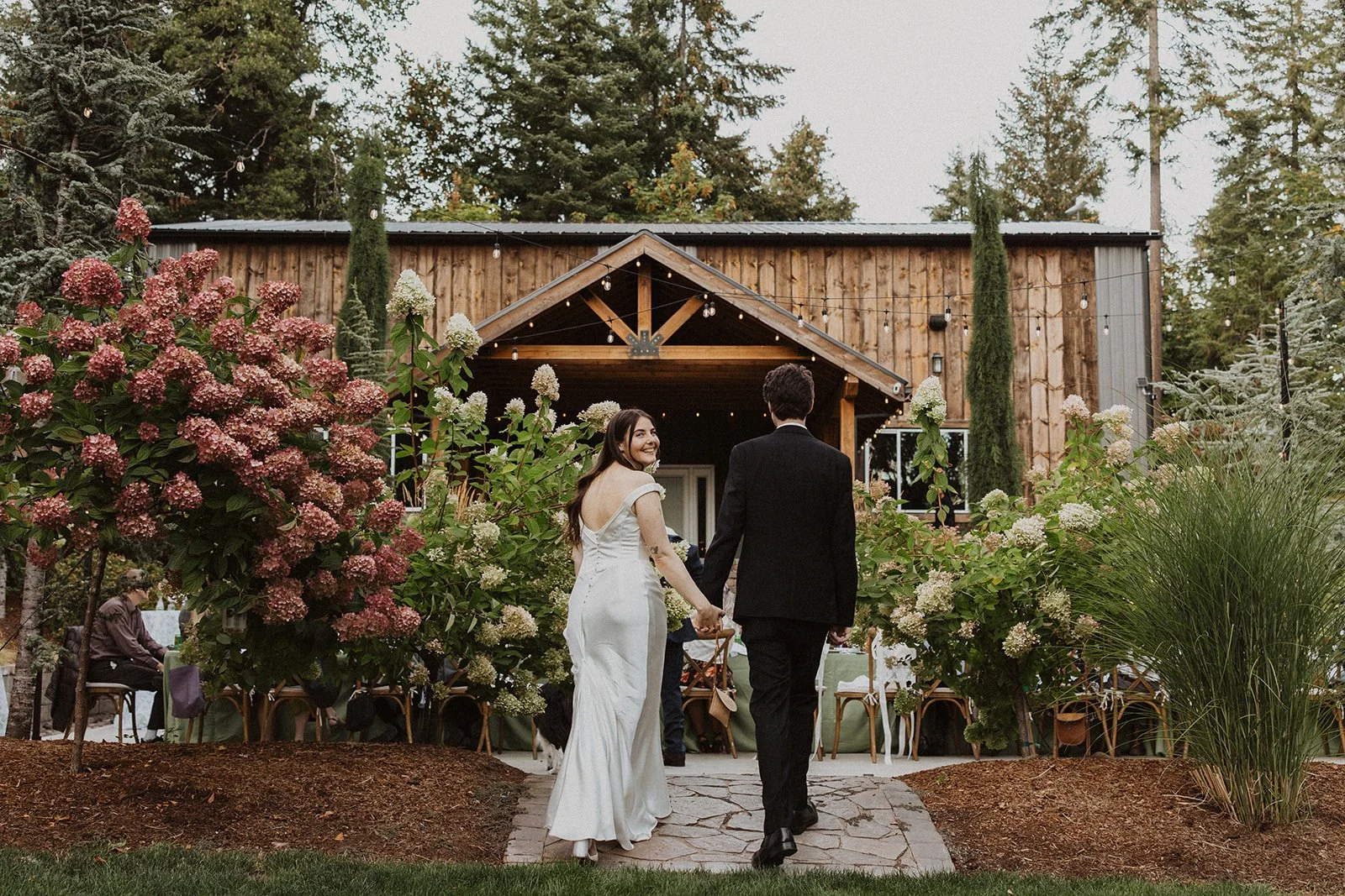 Walking back toward the lit reception hall at Rocky Hill Weddings & Events