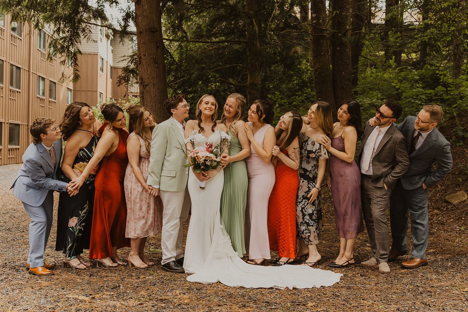 Wedding party laughing together on the lawn outside the main lodge