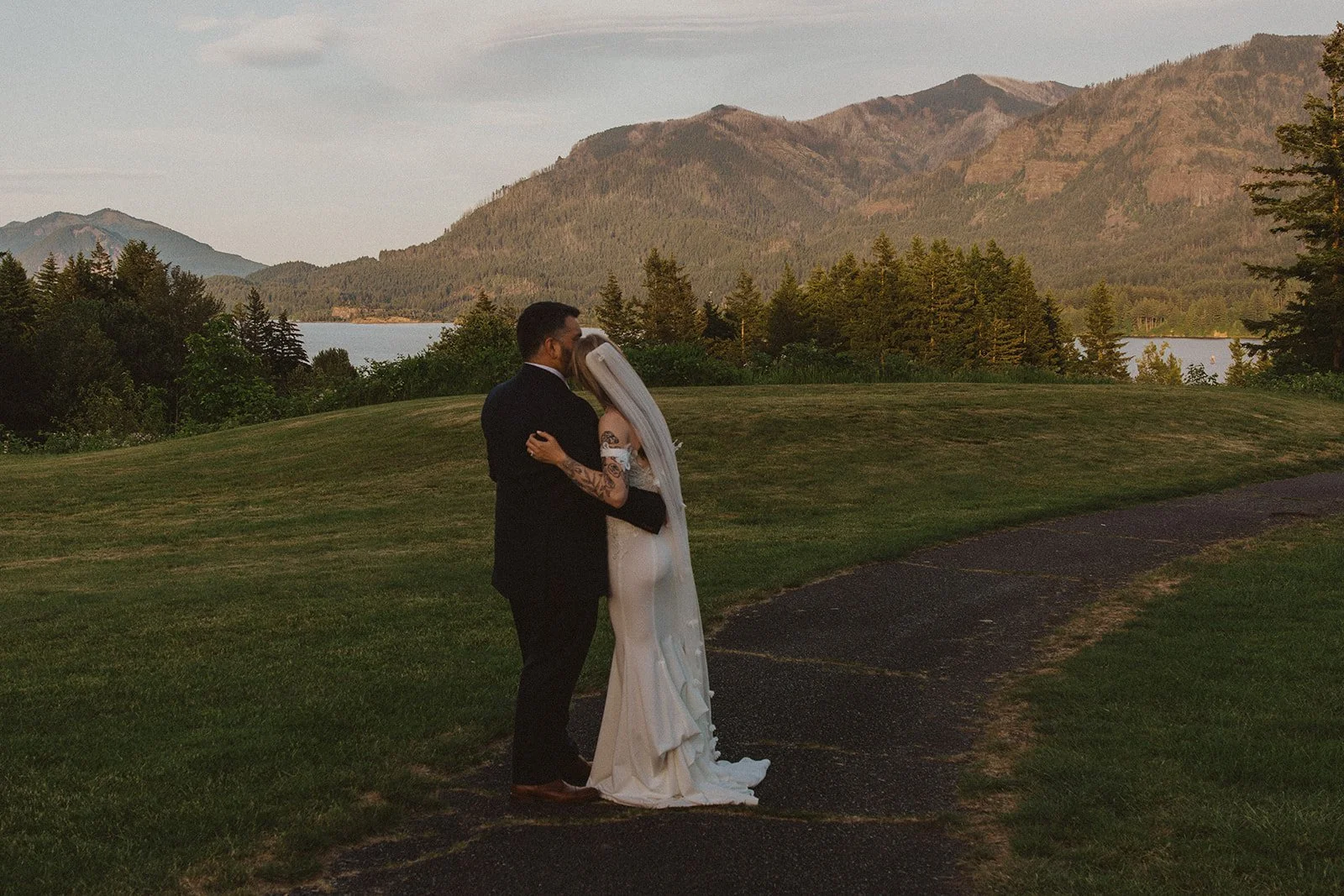 Bride and groom embracing during sunset portraits overlooking the Columbia River Gorge from Skamania Lodge.