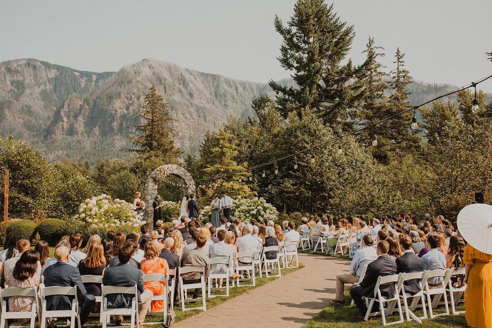 Wide view of a seated crowd at an outdoor ceremony under lights