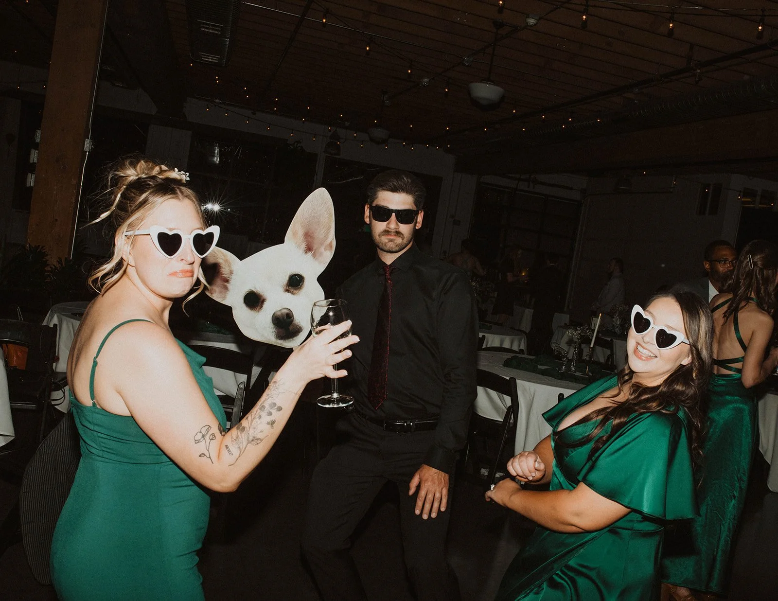 Bride and groom wearing heart-shaped sunglasses pose with drinks near the reception bar during their wedding celebration at The Castaway in Portland.