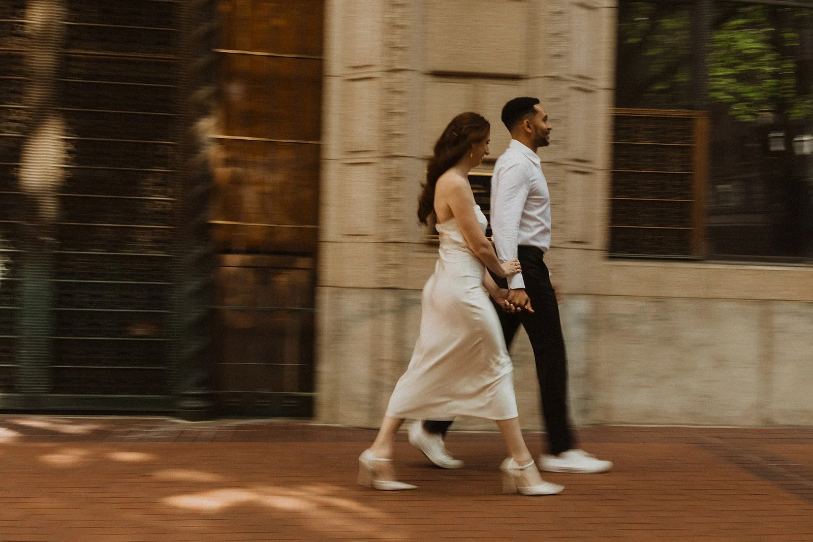 Engaged couple walking along a street in downtown Portland, Oregon