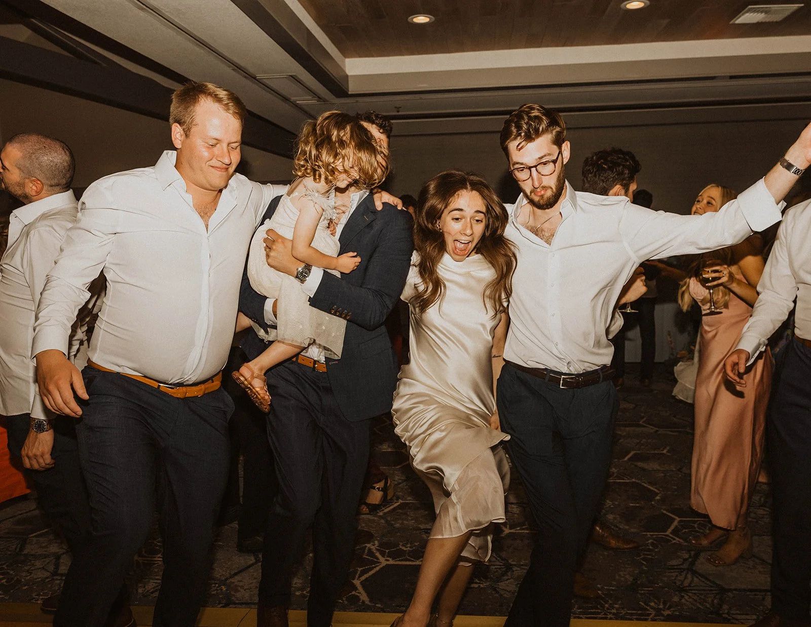 Bride dancing energetically with wedding guests during a fun-filled wedding reception party