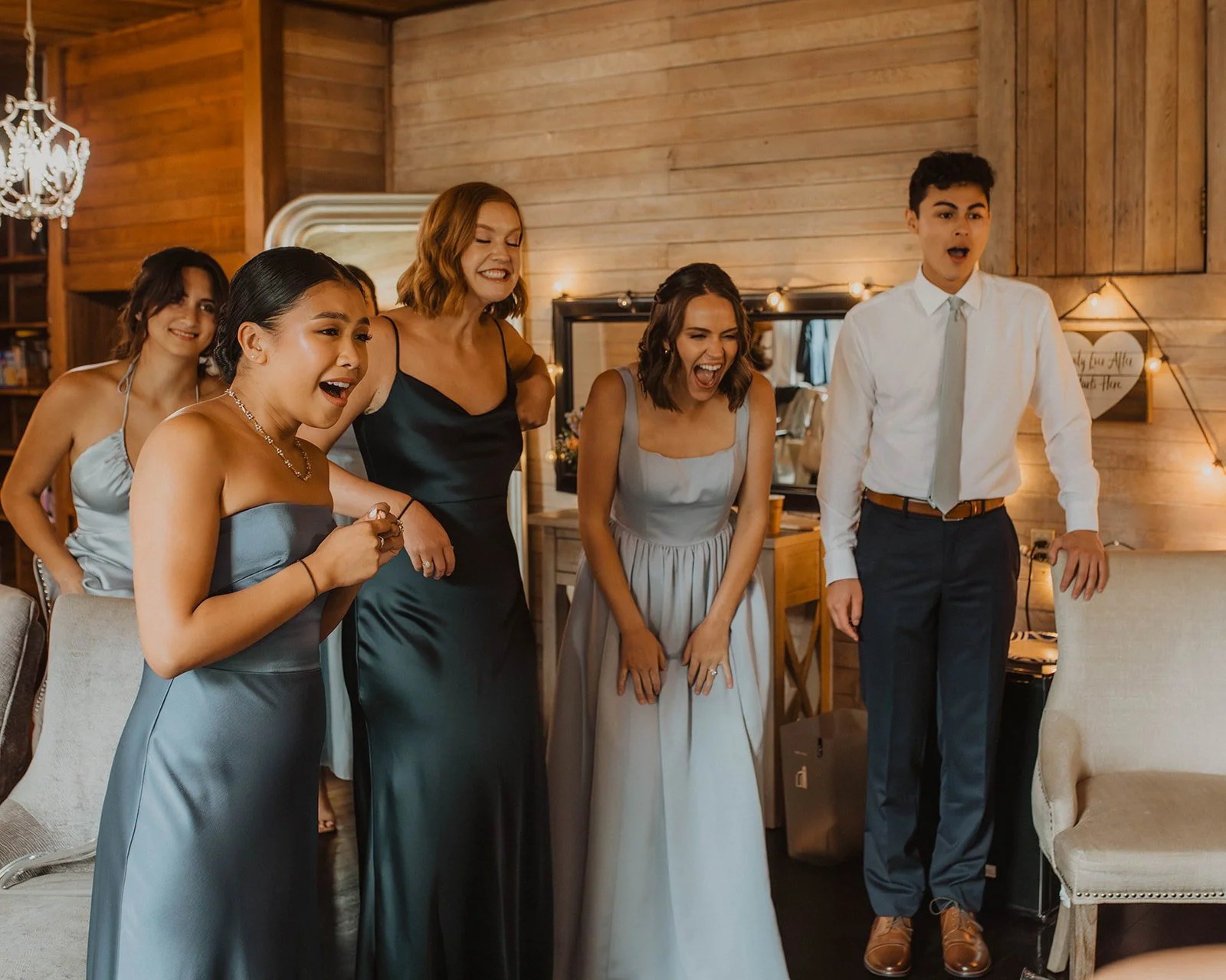 Bridal party reacting emotionally during the bride’s reveal inside a cozy wooden wedding suite at Cape Horn Estate.