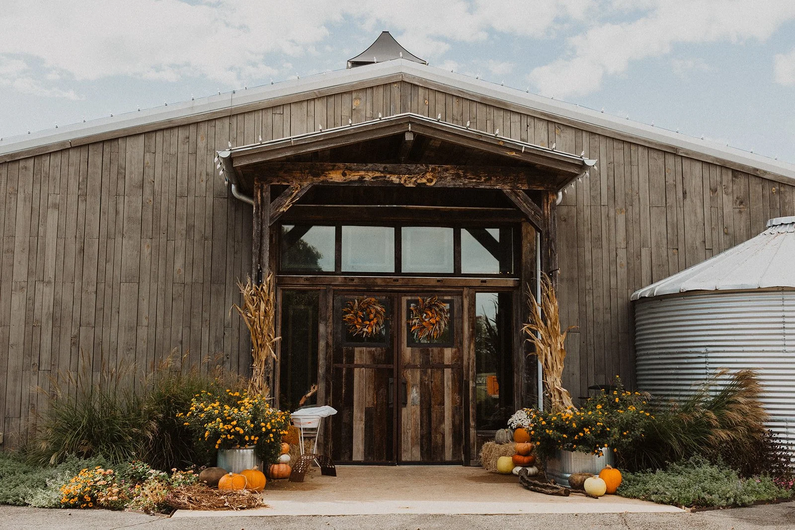 Exterior of the Bright Morning Farm reception barn decorated with seasonal flowers, pumpkins, and rustic fall details.