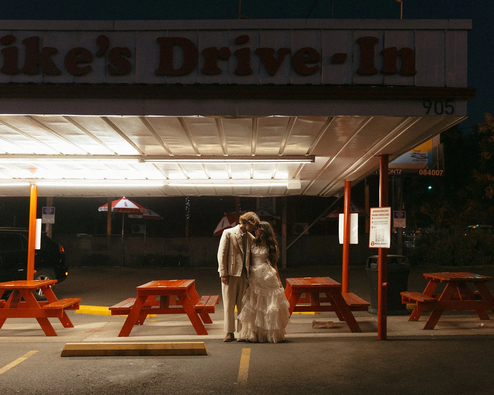 Couple sharing a quiet, intimate moment under soft overhead lights at a late-night diner, captured by a wedding photographer in Portland Oregon with a cinematic, moody feel.