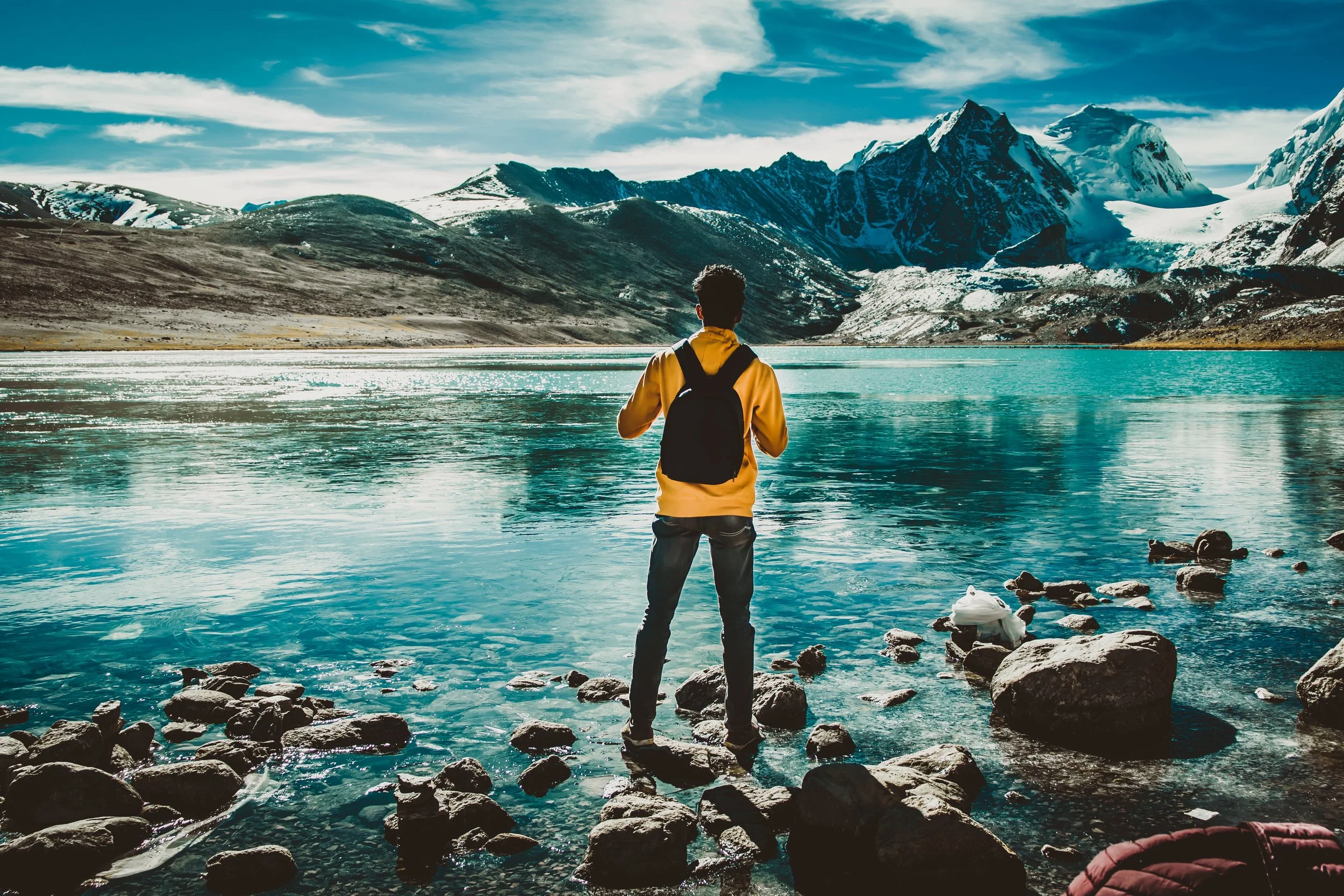photo-of-man-wearing-backpack-while-standing-on-rocks-3326178.jpg