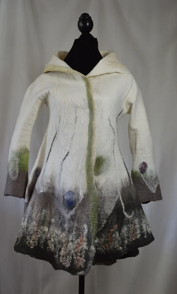 Winter White Nuno Felted Flared Coat Donna Lark larkstudios511@gmail.com donnalarkfelts.com Size XS $1,500.00 Nuno Felting is achieved through the stacking & layering of merino wool fibers onto hand dyed silk, carefully varying their lengths & alignments in a fashion that allows for controlled shrinkage. The resulting felt maintains just the right amount of movement & drape for its function as good design & clothing.