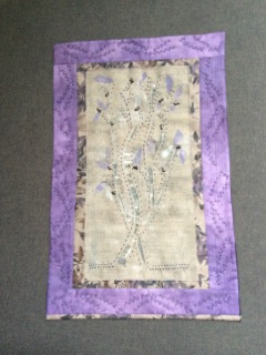 Lily 21” x 14” $150 Materials: Commercial fabric, painted fusible webbing. Technique: Designed, pieced, beaded, and quilted by artist.
