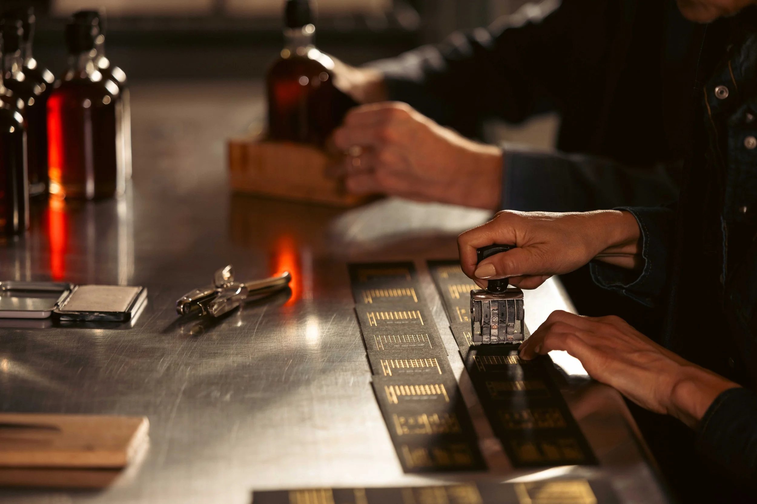 Laurel & Ash Farm stamping labels for maple syrup bottles