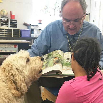 Roxy dog, Finn, is helping his friend to read.