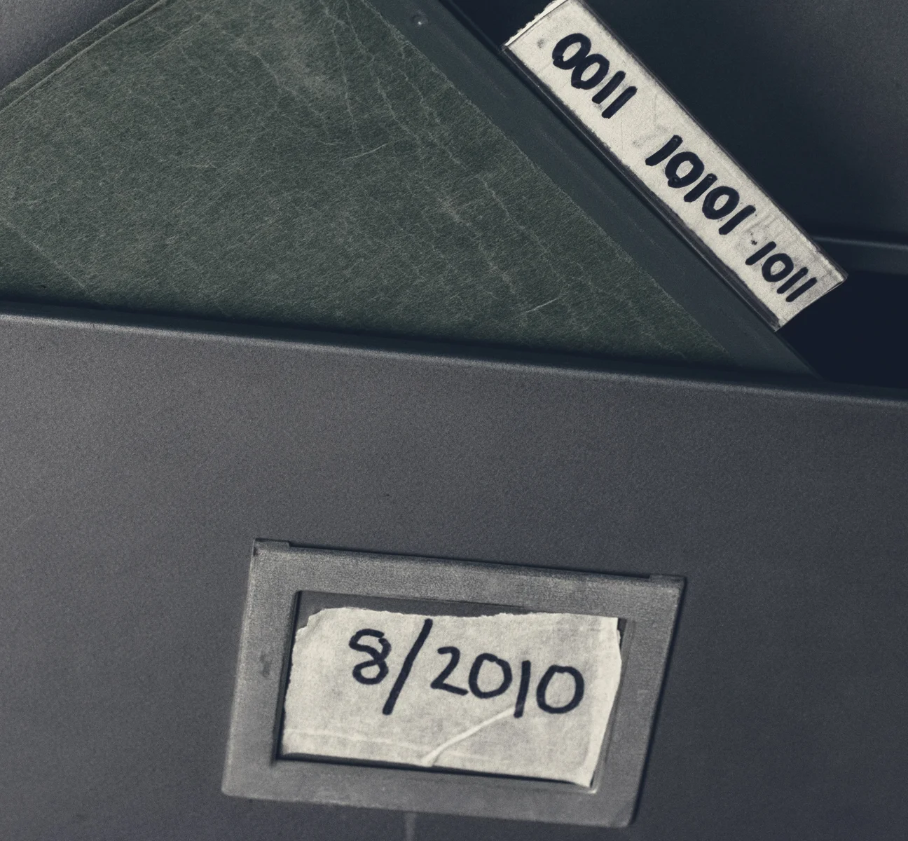 An additional folder, labeled “0011 10101 1011” has been inserted into a marked drawer with “8/2010” written on a piece masking tape.