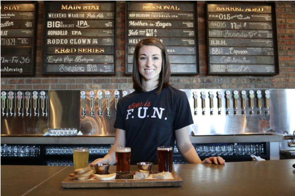 tapping into in-house food service for brewers and breweries photo of bartender offering beer flight with no food.png