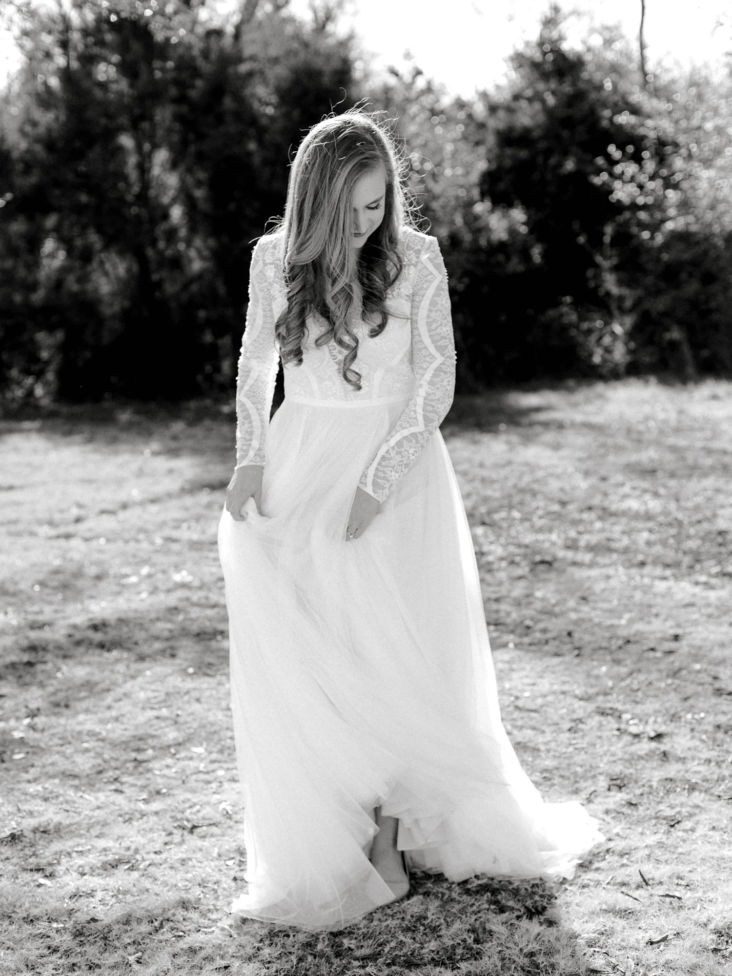 Black and white photo of bride in long sleeve Wtoo wedding dress showing her shoes on her wedding day.