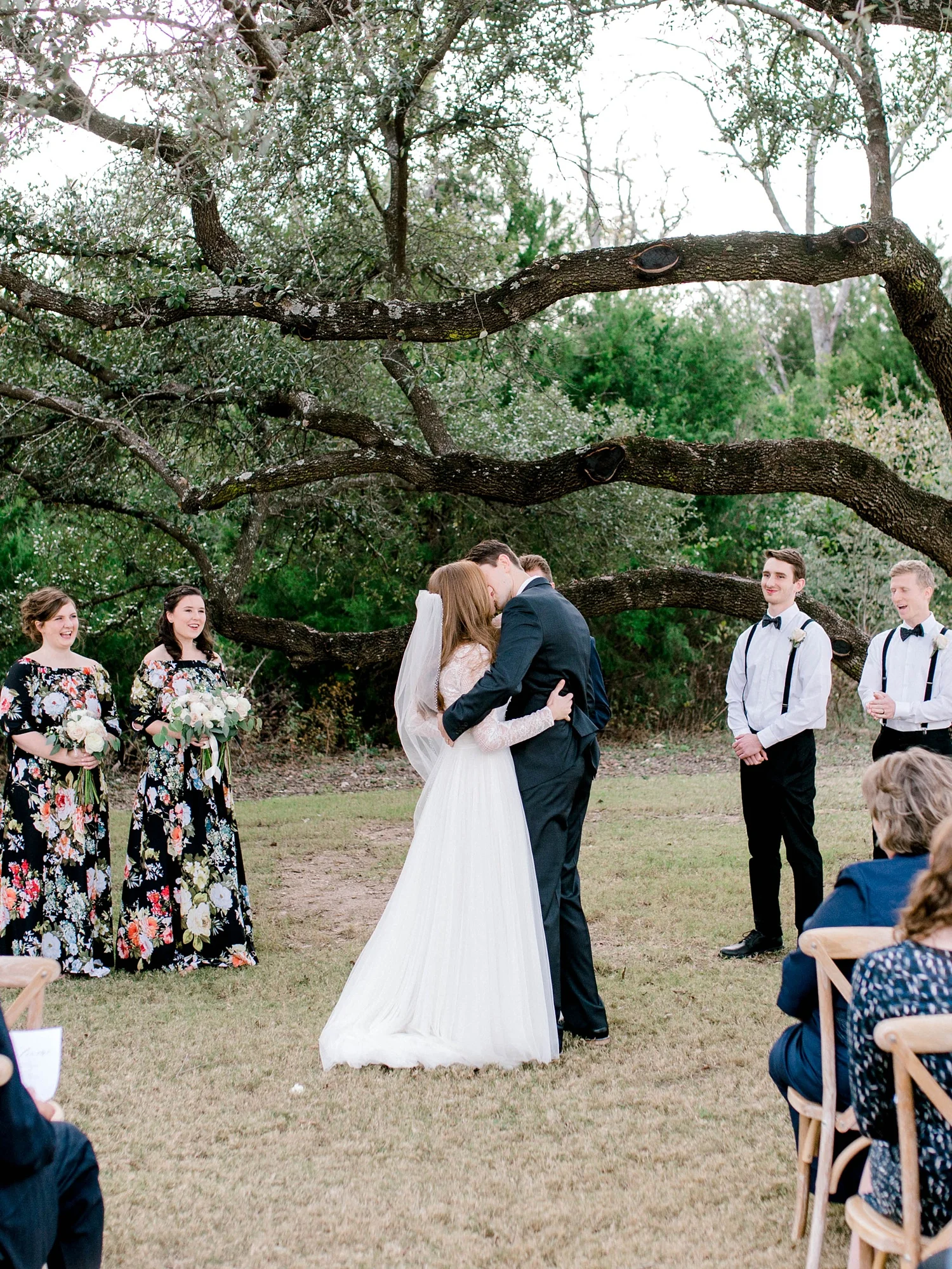 Bride and groom’s first kiss on their wedding day at the alter under an oak tree.