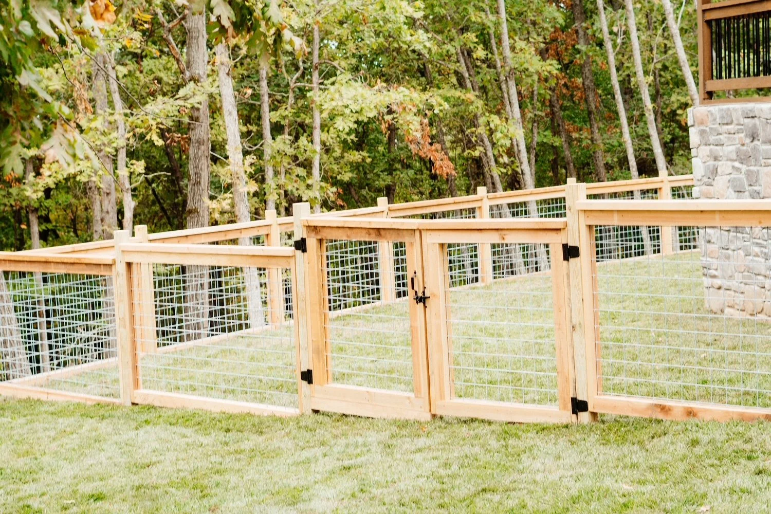 Wood and wire fence enclosing a residential backyard for pets and safety in Northwest Arkansas, installed by ABI Systems