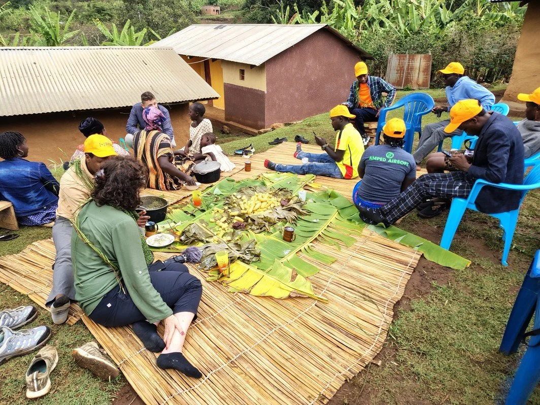 Eating traditional food and sharing stories during a Cooking with the Kapchorwa Mamas experience on Mount Elgon, East Africa.