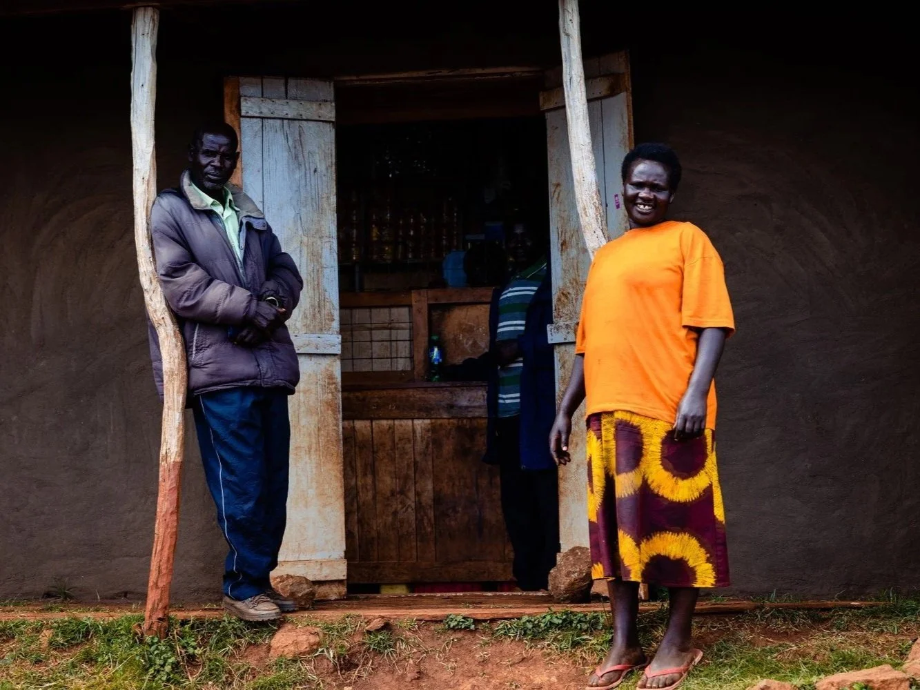 Men and a woman in front of a shop in Kapchorwa Town, on the slopes of Mount Elgon