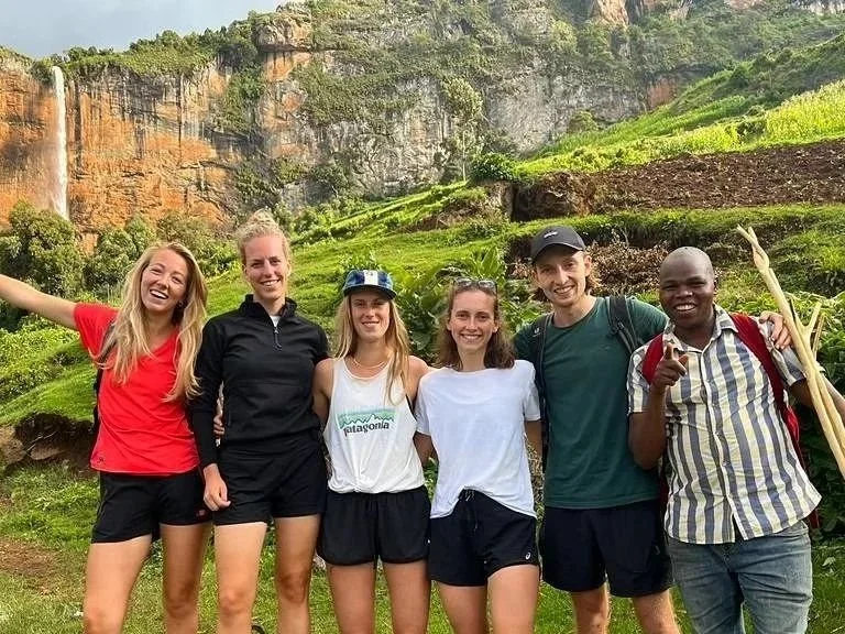 A group of happy hikers at Mengia waterfall, endpoint of the Kapchorwa-Benet Trail. Mount Elgon, Uganda.