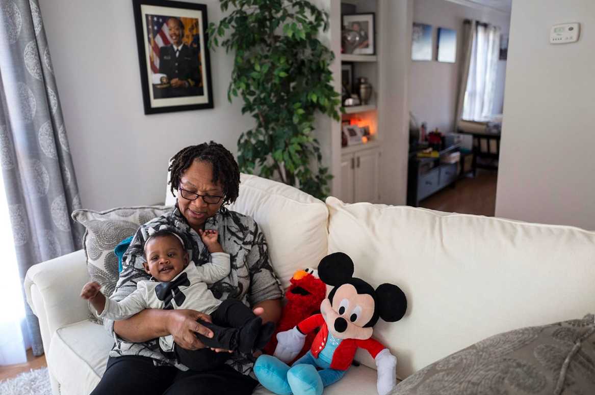 Wanda in the living room of the town house she shares with Soleil. A photo of Shalon is in the background. (Sheila Pree Bright for ProPublica)