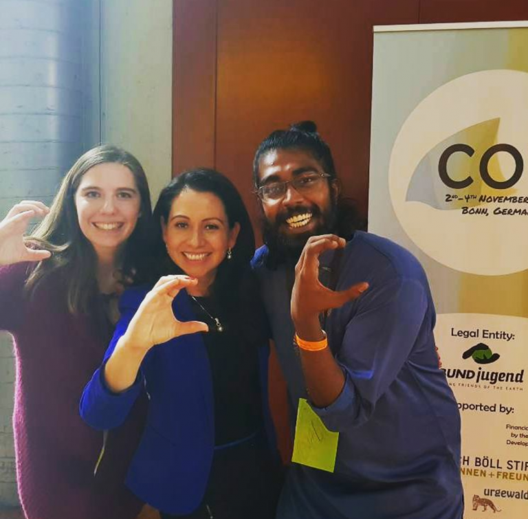 From left, the Author, UNFCCC Focal point on Education & Youth, and Amalen flash the Climate Sign after moderating the opening ceremony of COY13