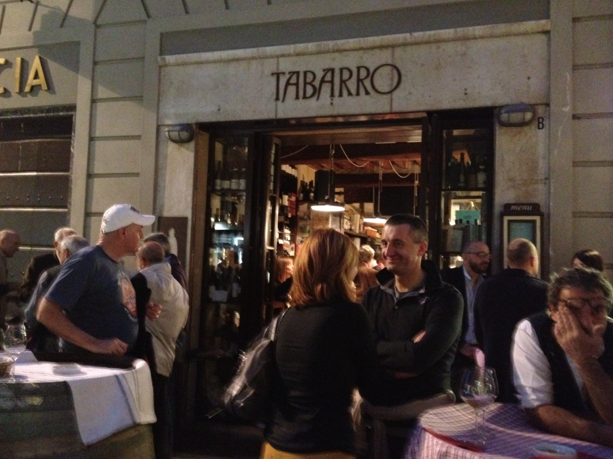 La animada vereda y el pequeño interior de la enoteca Tabarro , cita ineludible con el placer.